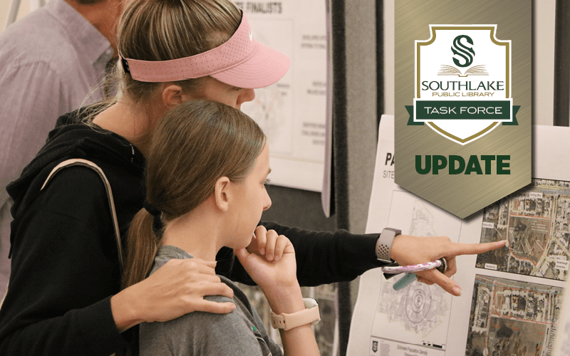 A mother points to a map of a proposed library site for her daughter.