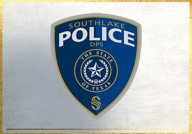 Blue and gold police badge with "Southlake Police DPS" at the top, "The State of Texas" and a star surrounded by a wreath in the center, and a stylized "S" at the bottom. The background is a textured white surface with a gold border.