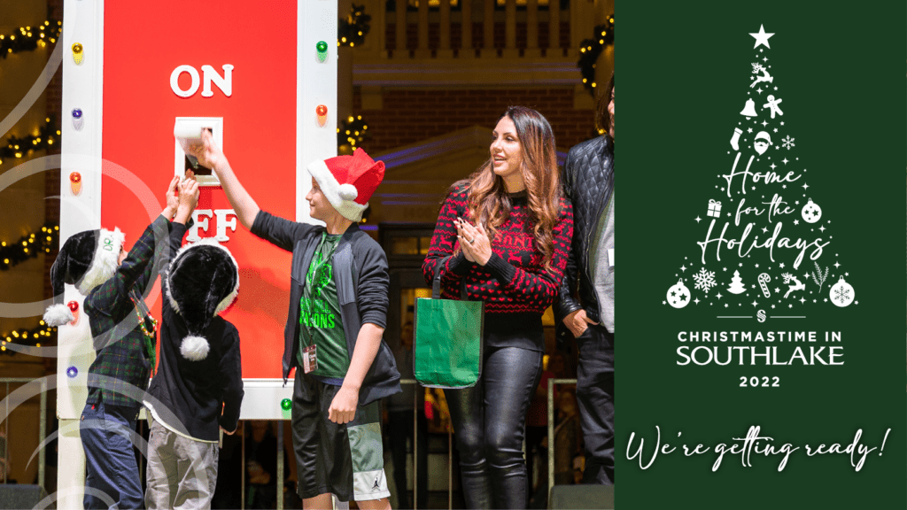 Three people, including a child in a Santa hat, flip a switch labeled "ON" to illuminate festive decorations. A woman watches, smiling, wearing a Christmas sweater. Text reads "Christmastime in Southlake 2022 - We're getting ready!" with a tree graphic.