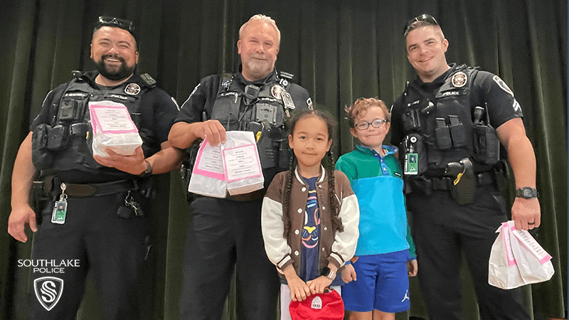 The Southlake Police School resource Officers are shown with two children.