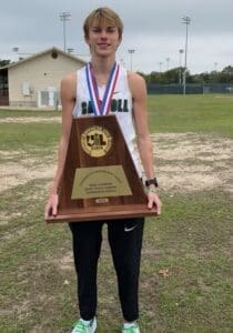 An athlete posing with a championship trophy
