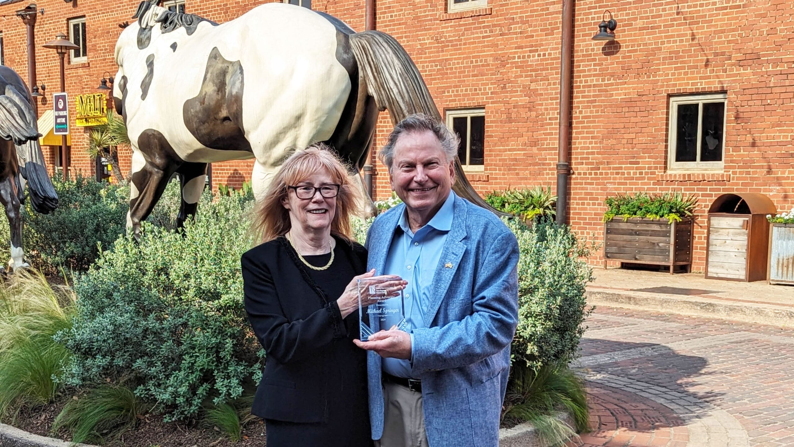Two people posing with an award