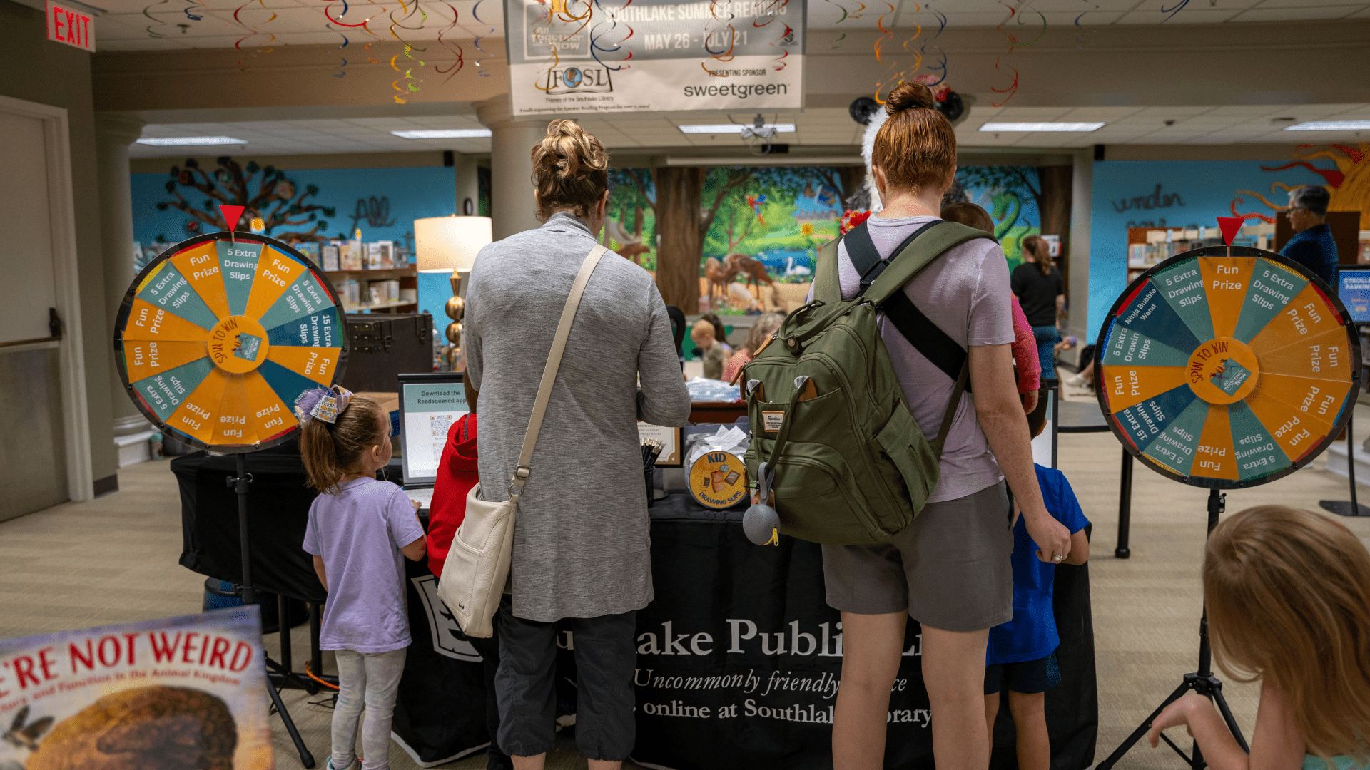 Parents and kids enjoying Summer Reading picking their prize from the spinning prize wheel