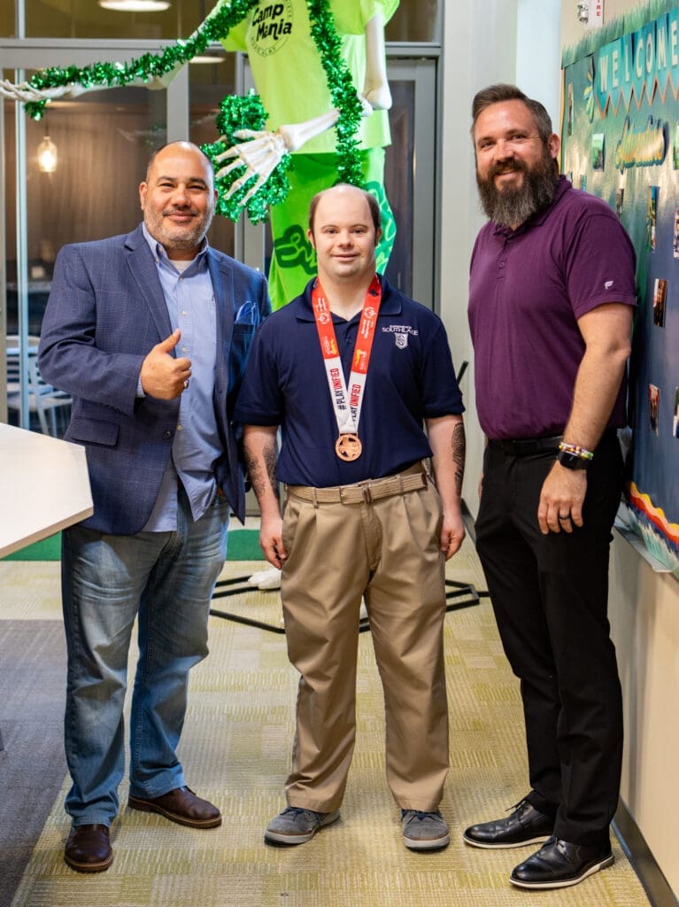Three men standing together smiling