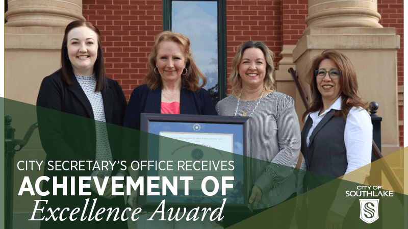 Four women stand in front of a building holding an award. The image includes text: "City Secretary’s Office Receives Achievement of Excellence Award" and "City of Southlake." The women are smiling and dressed in business attire.