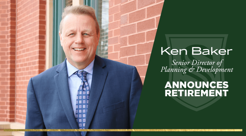 A man in a blue suit and patterned tie smiling in front of a brick wall. The text reads, "Ken Baker, Senior Director of Planning & Development, Announces Retirement.