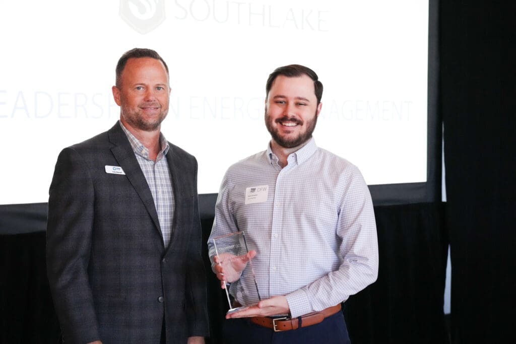 Photo of two men, one holding an award