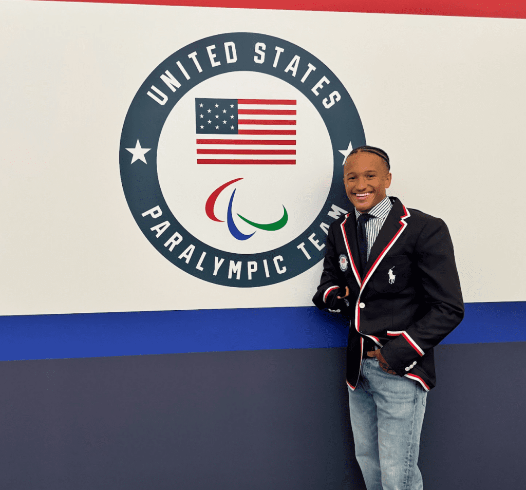 Photo of a man standing next to a United States Flag logo