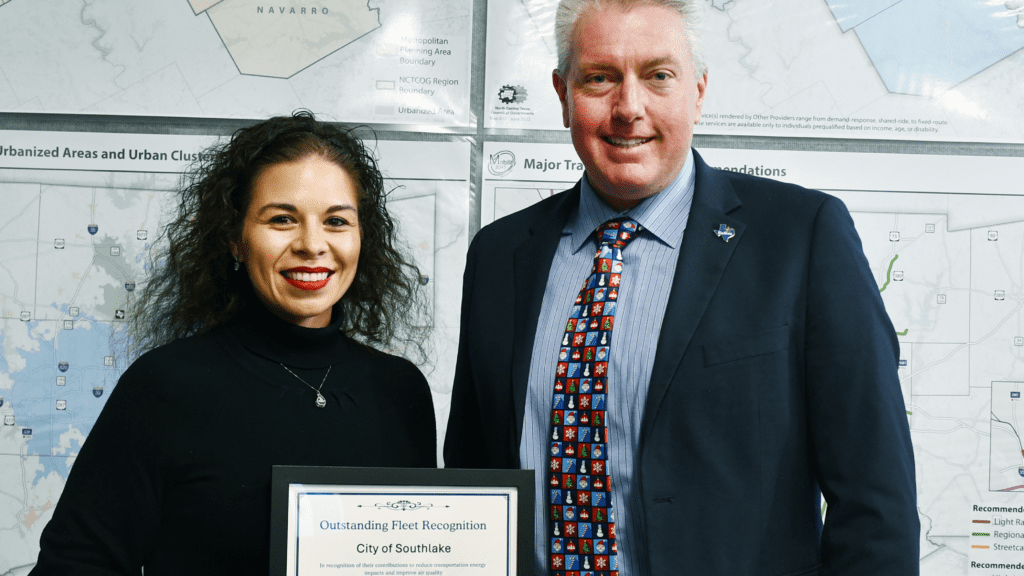 Photo of a man and woman holding an award