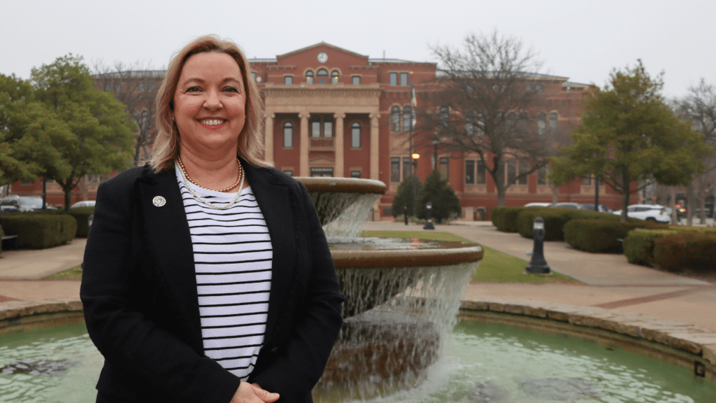 Photo of a woman smiling in front of a government building