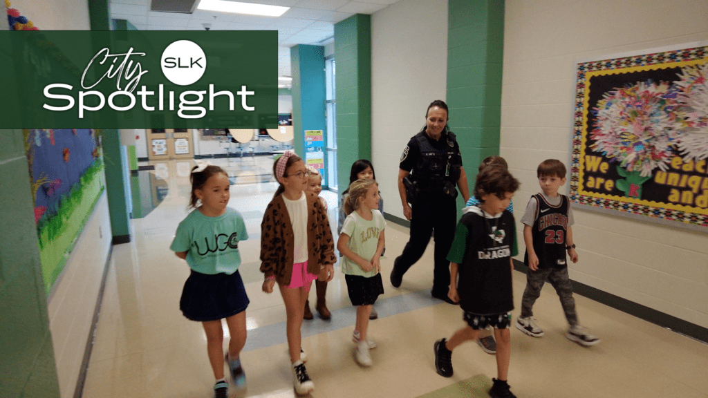 Officer Kim Smith walks down the hallway with students.