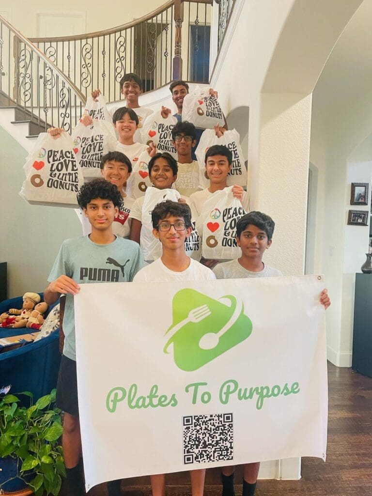 A group of boys stand on a staircase, holding bags labeled “Peace, Love & Little Donuts.” In front, three boys hold a banner reading “Plates To Purpose” with a logo of a fork and leaf, and a QR code. They are in a home setting.