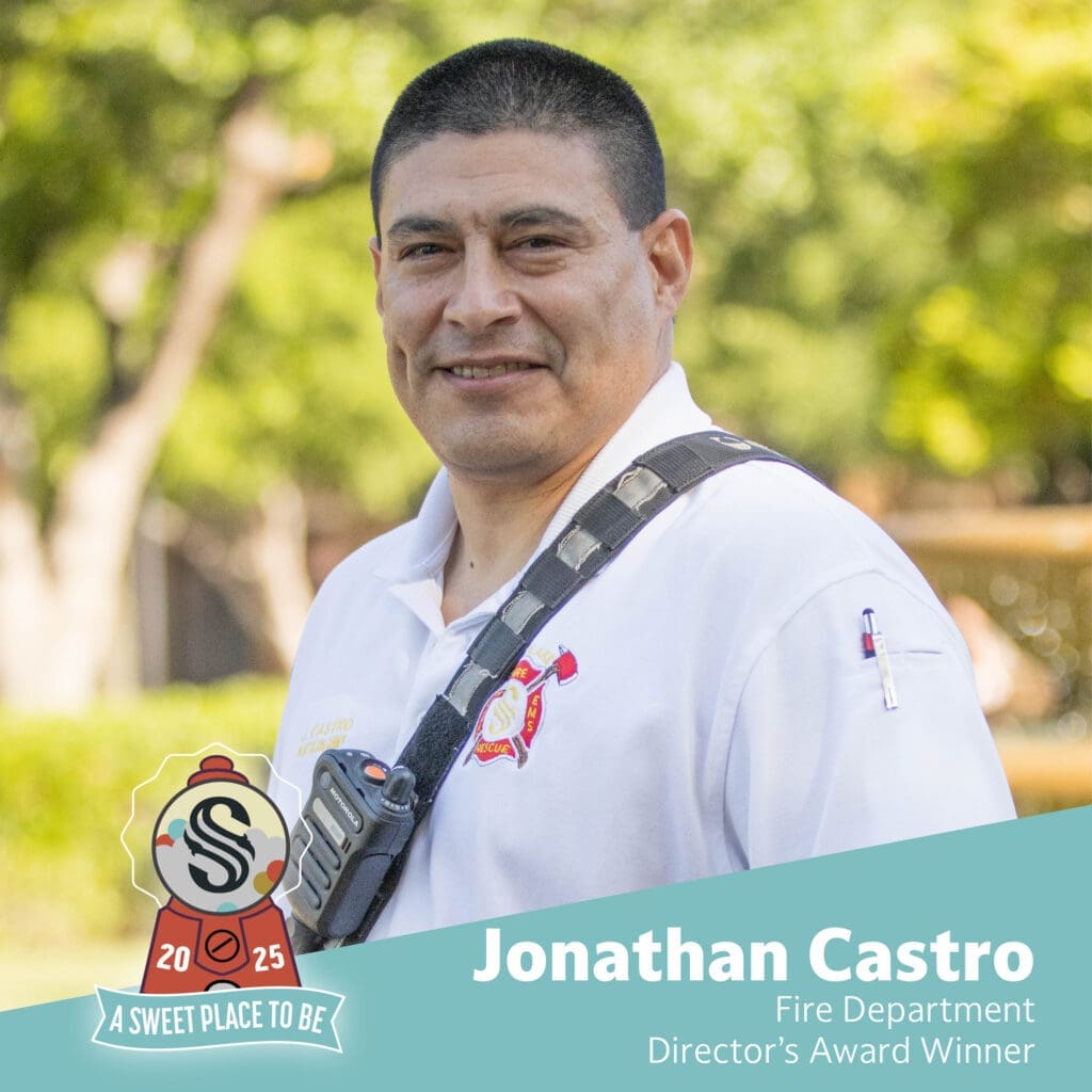 A man in a white fire department shirt with a walkie-talkie stands outside, smiling. Text reads: "Jonathan Castro, Fire Department, Director's Award Winner. 2025. A Sweet Place to Be.
