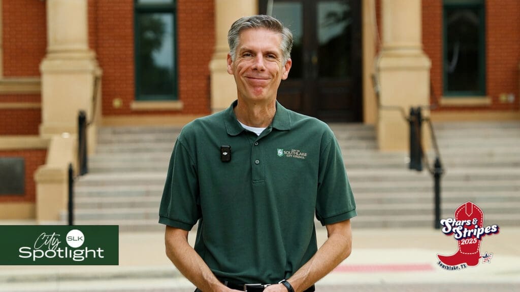 Mayor Shawn McCaskill in a green polo shirt stands smiling in front of Southlake Town Hall. Logos in the image read “City Spotlight SLK” and “Stars & Stripes 2023” with a red boot illustration.