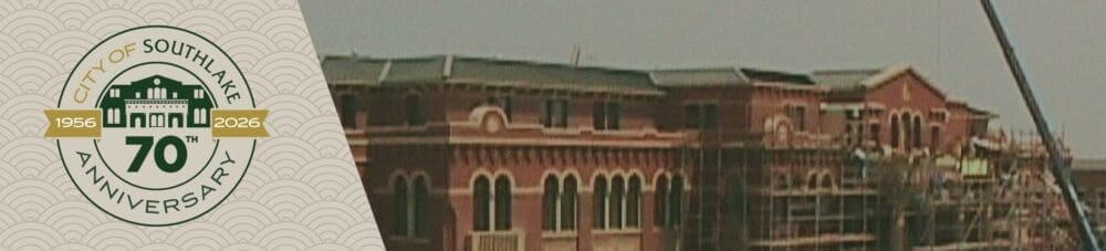 A circular logo for the City of Southlake’s 70th anniversary (1956–2026) is on the left, next to an under-construction brick building with scaffolding and a crane on the right.