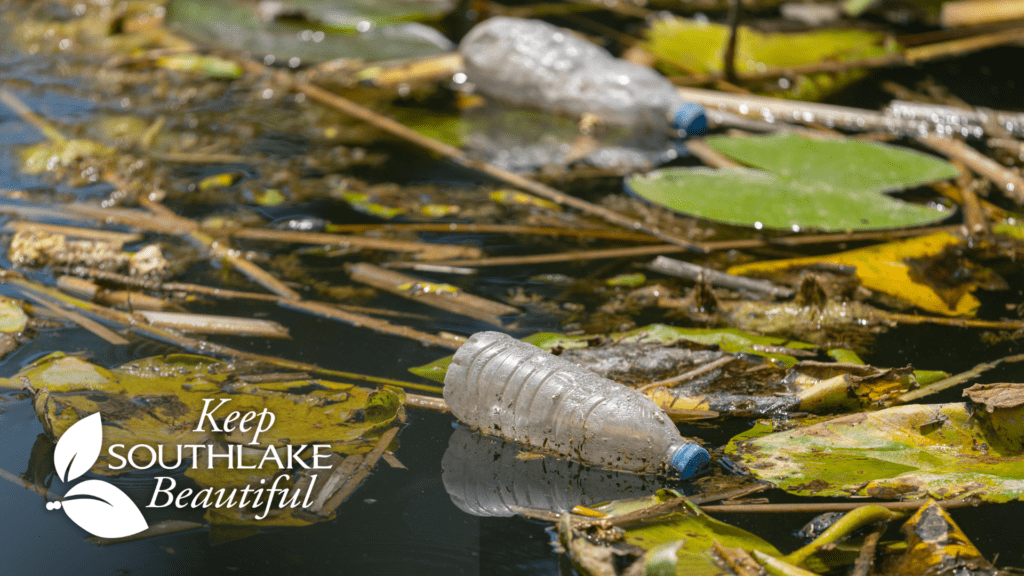 Plastic bottles and other litter float among lily pads and debris in a pond. The words "Keep Southlake Beautiful" and a leaf logo appear in the bottom left corner, promoting environmental cleanliness.